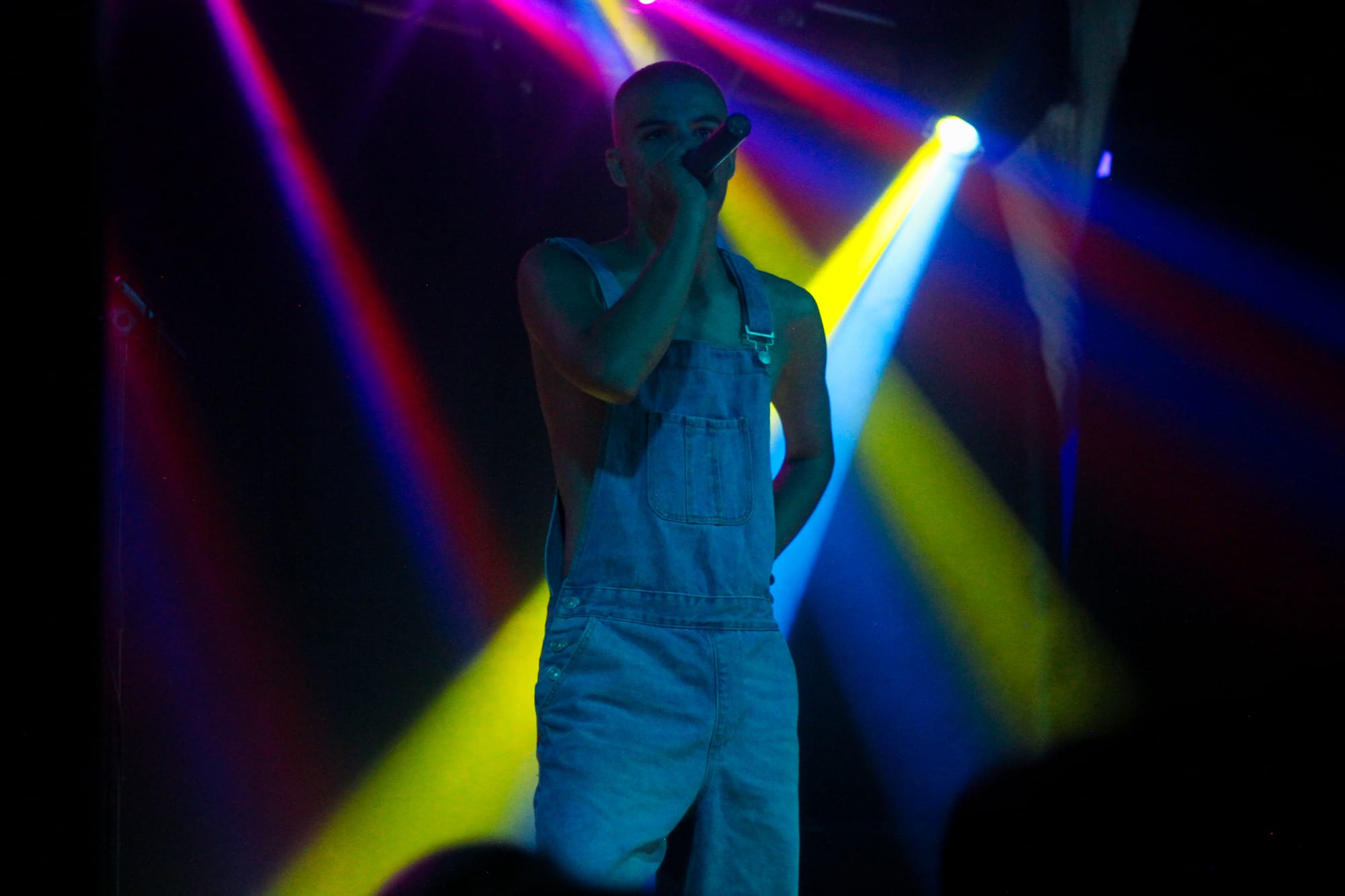 Ssadcharlie at the Fleece Bristol on stage with multicoloured lights in the background